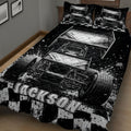 Close bedroom view of a black and white dirt track racing quilt with sprint cars and checkered graphics