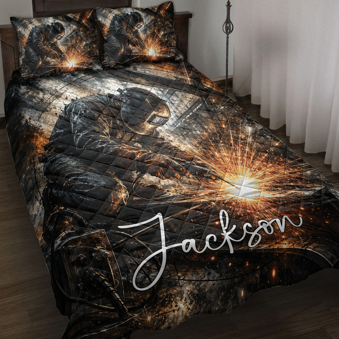 Welder quilt blanket displayed on a bed with dramatic black, gray, and orange welding artwork