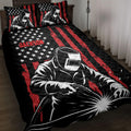 Welder quilt blanket displayed on a bed with black, red and white stars-and-stripes artwork