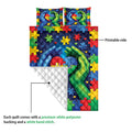 Close detail of autism quilt showing printable puzzle-piece artwork, supportive hands, and a quilted white backing