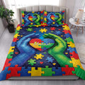 Autism quilt blanket styled in a bright bedroom with colorful puzzle pieces, hearts, and supportive hands