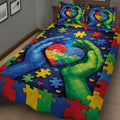 Colorful autism quilt bedding with puzzle pieces, heart details, and supportive hands in a cozy bedroom