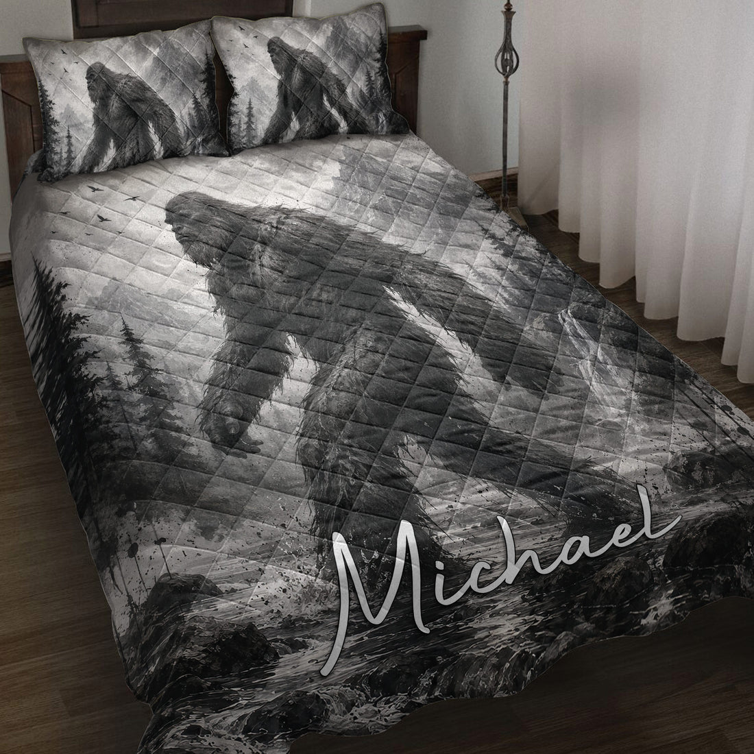 Bigfoot quilt blanket displayed on a bed with grayscale mountain, forest, waterfall, and Sasquatch artwork