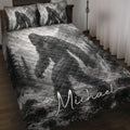 Bigfoot quilt blanket displayed on a bed with grayscale mountain, forest, waterfall, and Sasquatch artwork