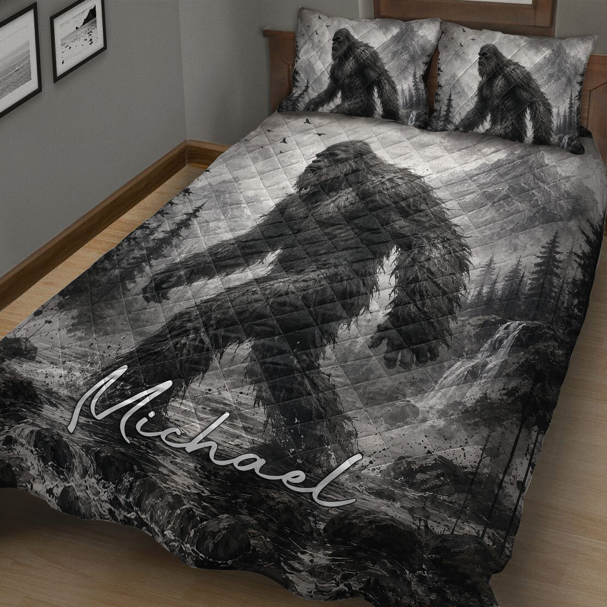 Close bedroom view of a Bigfoot quilt blanket with grayscale wilderness and waterfall artwork