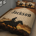 Close view of a Western cowboy quilt blanket featuring a horseback rider silhouette and golden desert sunset landscape