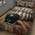 Close view of bowling quilt bedding with pins and a black ball across the textured bedspread