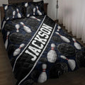 Bowling quilt blanket displayed on a bed with black balls, white pins, and a dark blue lane-inspired design