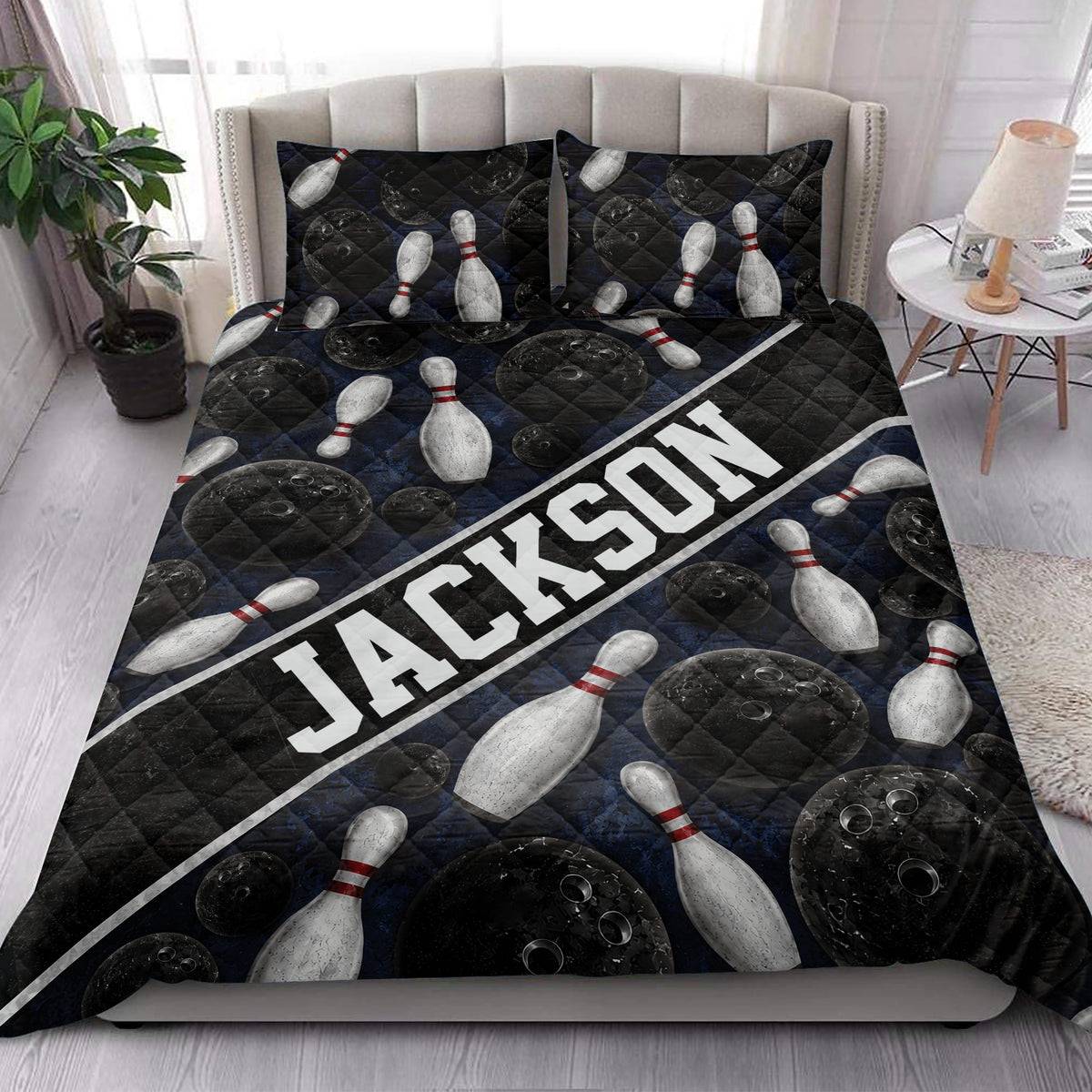 Bowling quilt blanket styled on a bedroom bed with black bowling balls and white pins
