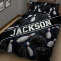 Close bedroom view of a bowling quilt blanket featuring scattered pins, balls, and a bold lane stripe