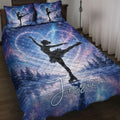 Blue galaxy ice skating quilt blanket displayed on a bed with figure skater silhouettes and scenic pillows