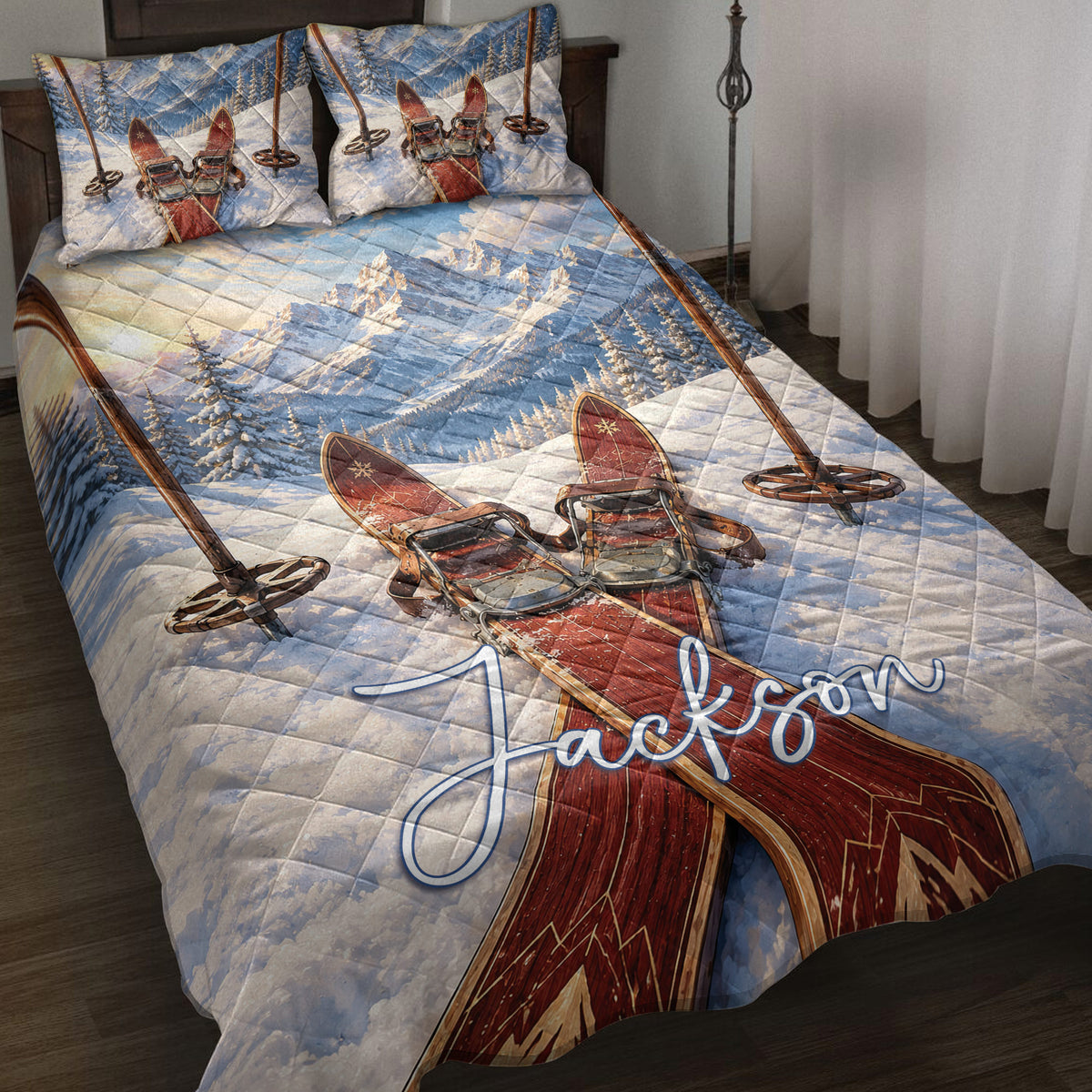 Skiing quilt blanket displayed on a bed with snowy mountains, crossed skis, and ski poles