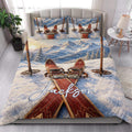 Skiing quilt blanket styled on a bedroom bed with snowy alpine mountain artwork