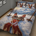 Mountain skiing quilt bedding displayed across a bed with skis and winter scenery