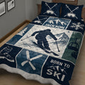 Close bedroom view of a navy skiing quilt with skier, alpine mountains, ski goggles, boots, and winter sports artwork