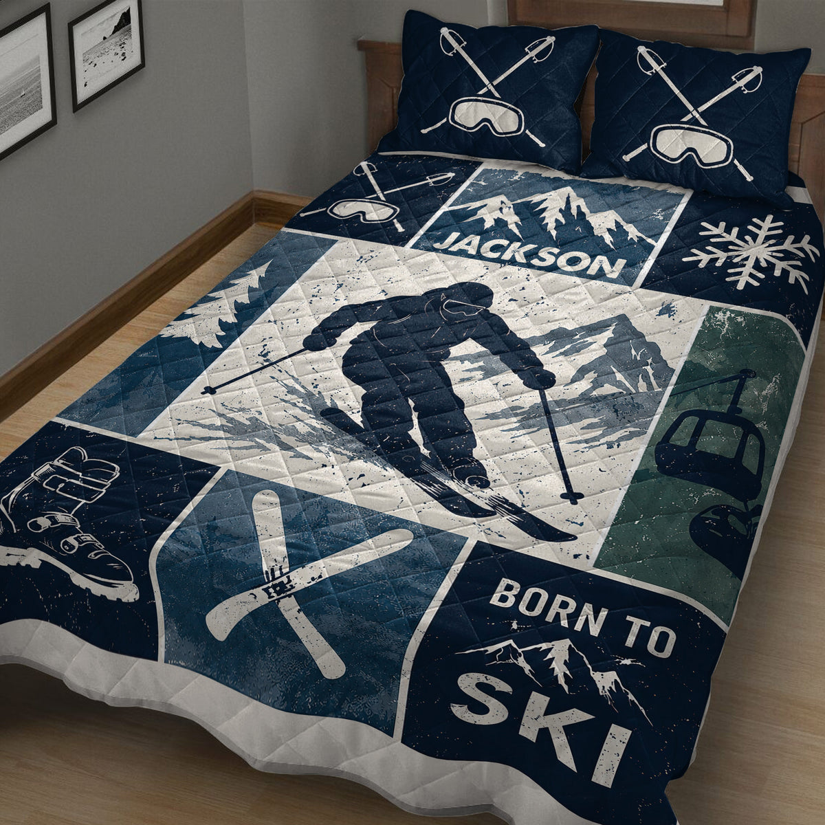 Close bedroom view of a navy skiing quilt with skier, alpine mountains, ski goggles, boots, and winter sports artwork