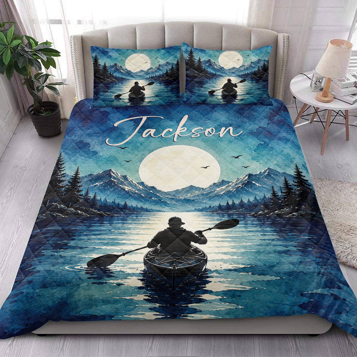 Kayak quilt blanket styled in a bright bedroom with mountain lake artwork and a paddler on the water