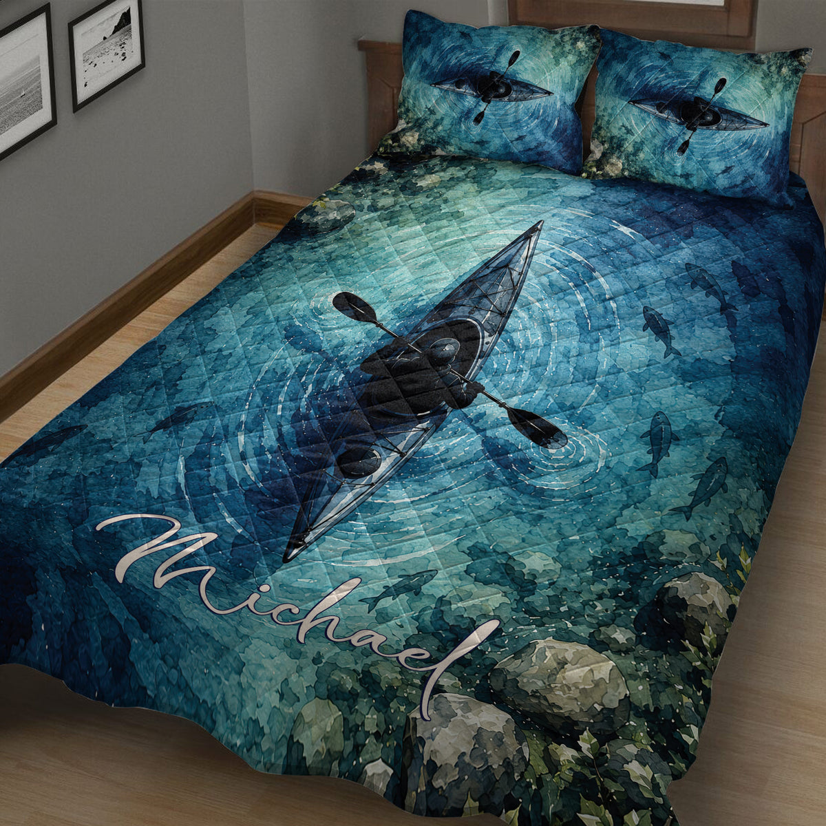 Close bedroom view of a blue kayak quilt blanket with paddler artwork, fish, and watercolor-style scenery