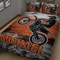 Angled bedroom view of a motocross quilt blanket featuring dirt bikes and rider silhouettes