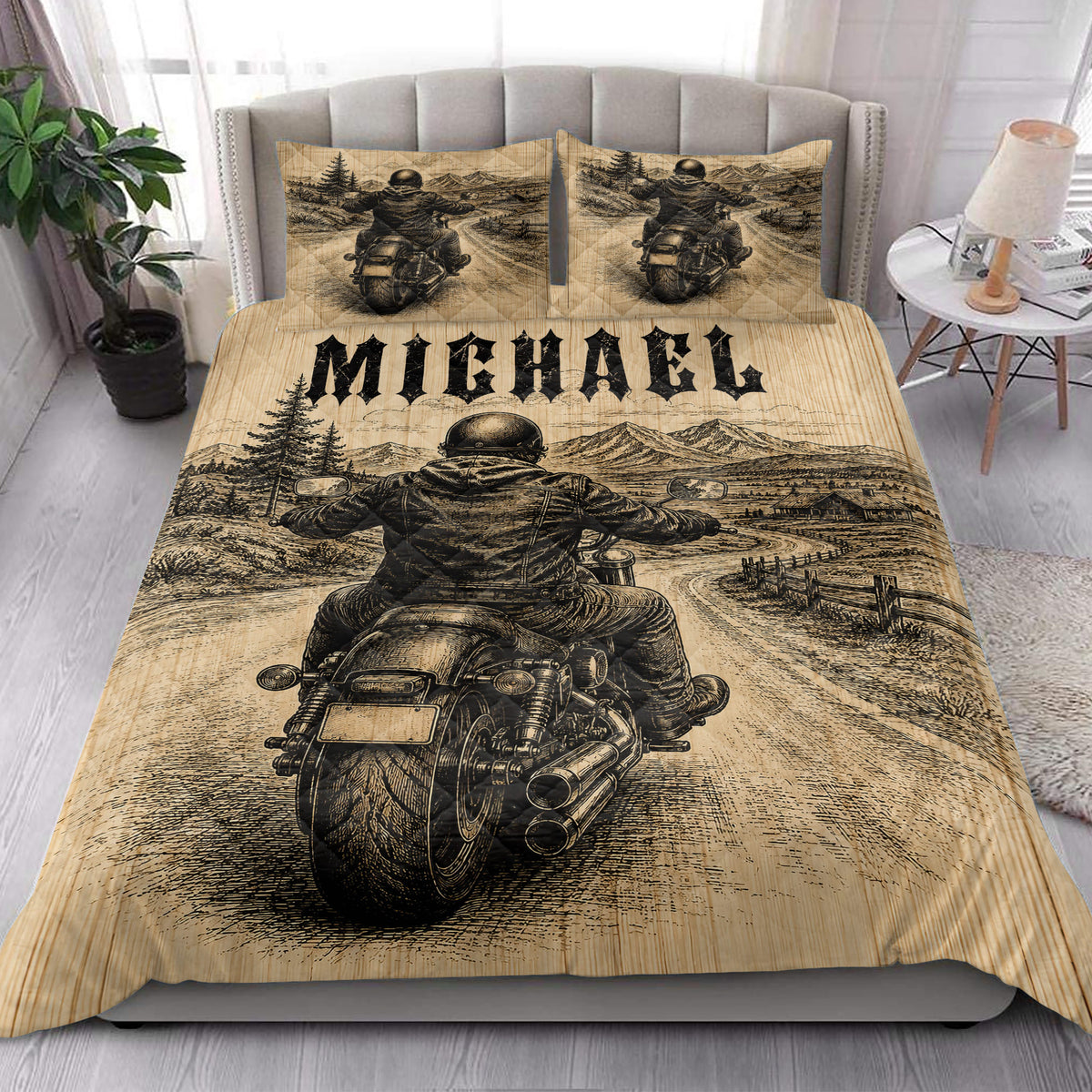 Biker quilt bedding styled in a bright bedroom with motorcycle rider, mountain landscape, and rustic road artwork
