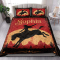 Cowgirl quilt bedding styled in a bright bedroom with red desert artwork, horseback silhouettes, and Western accents