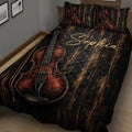 Close bedroom view of a black violin quilt blanket with large reddish-brown violin and bow artwork