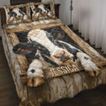 Dairy cow quilt blanket on a bed with rustic wood artwork, cow pillows, wheat and wildflower details