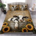 Dairy cow quilt blanket styled in a bright bedroom with cow and sunflower artwork