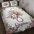 Nurse quilt blanket displayed on a bed with floral stethoscope artwork in burgundy, pink, white, and green