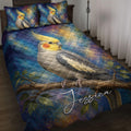 Cockatiel quilt blanket displayed on a bed with colorful blue and gold artwork and matching bird pillows