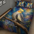 Close bedroom view of a cockatiel quilt blanket with colorful painterly artwork and branch details