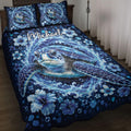 Blue sea turtle quilt blanket spread across a bed with ocean waves, bubbles, and tropical flowers