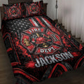 Firefighter quilt blanket displayed on a bed with fire department emblems, helmet artwork, stars, and red-black graphics