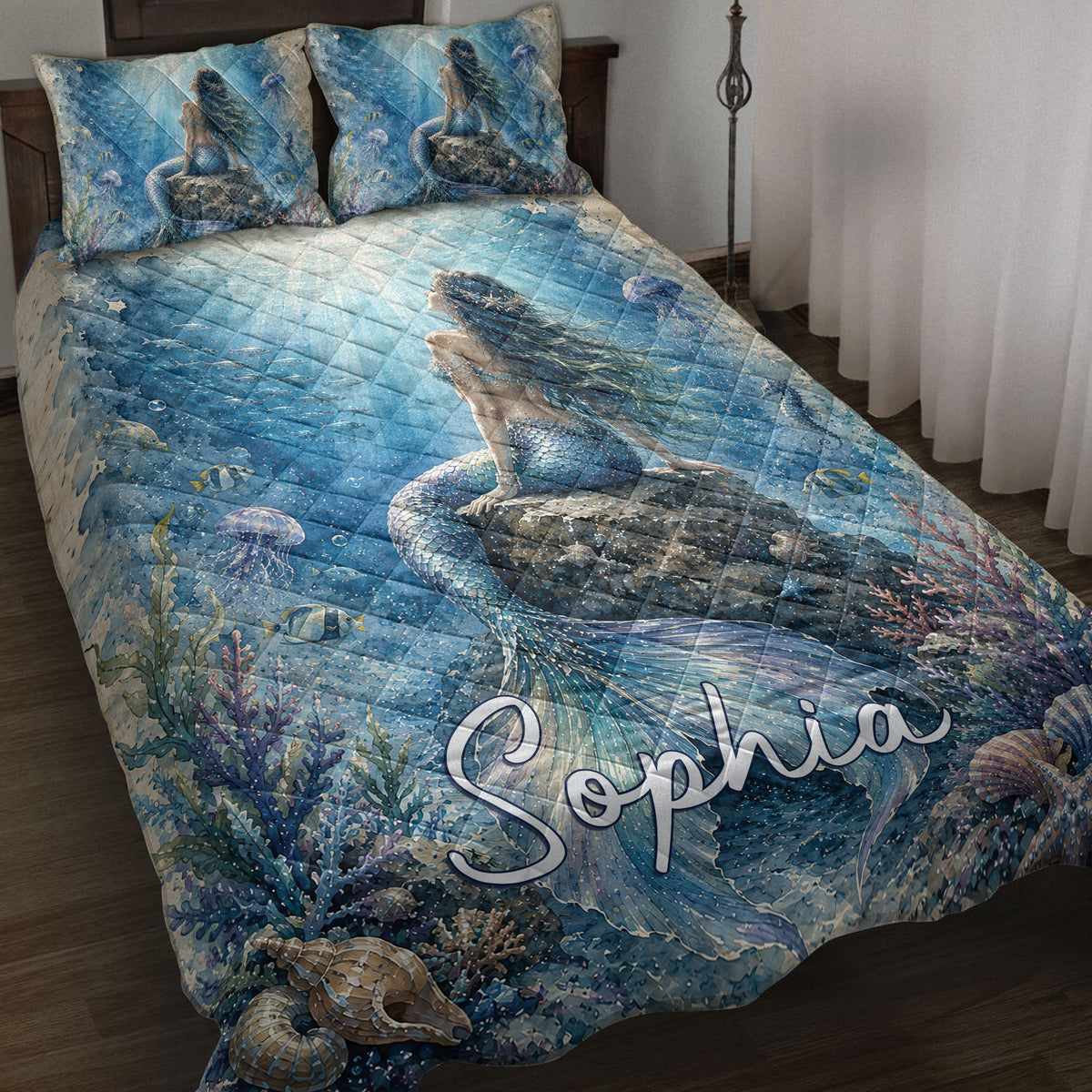 Blue mermaid quilt blanket displayed on a bed with coral, fish, jellyfish, and underwater artwork