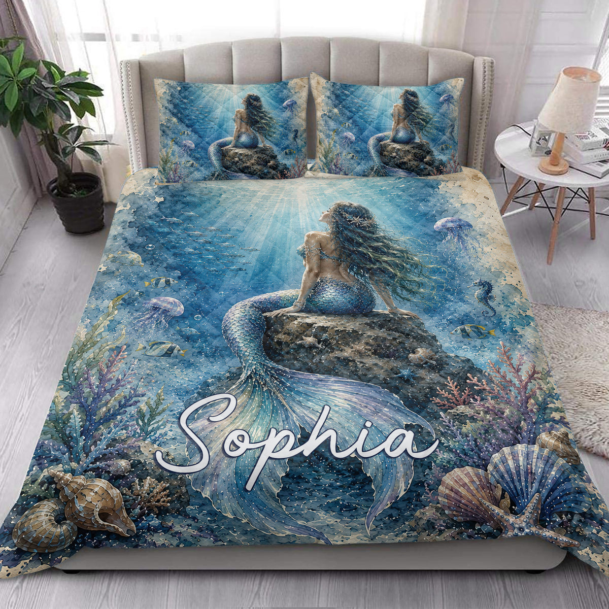 Mermaid quilt blanket styled in a bright bedroom with underwater coral and sea life artwork