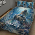 Close bedroom view of a blue mermaid quilt with coral, fish, jellyfish, and ocean details