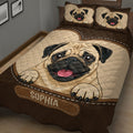 Close bedroom view of a brown and tan pug quilt blanket with matching illustrated pug pillow designs
