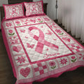 Pink breast cancer awareness ribbon quilt blanket displayed on a bed with floral and butterfly patchwork