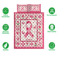 Pink breast cancer ribbon quilt blanket shown with floral patchwork, hearts, and breathable bedding features