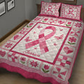 Close view of a pink breast cancer ribbon quilt blanket with butterflies, flowers, hearts, and patchwork borders