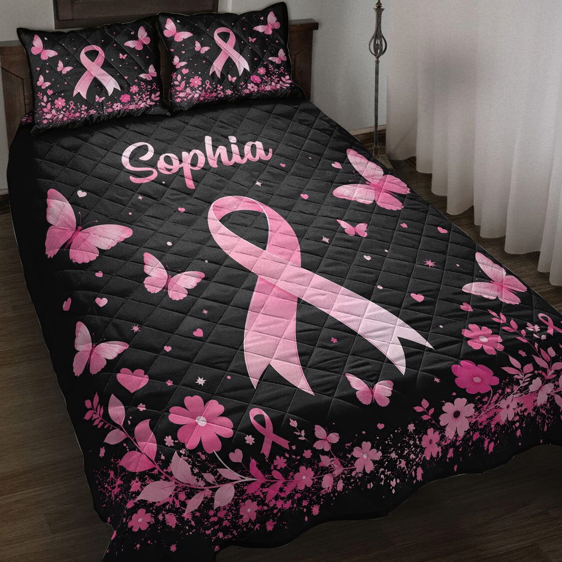 Black breast cancer quilt blanket with pink ribbons, butterflies, flowers, and heart accents on a bed