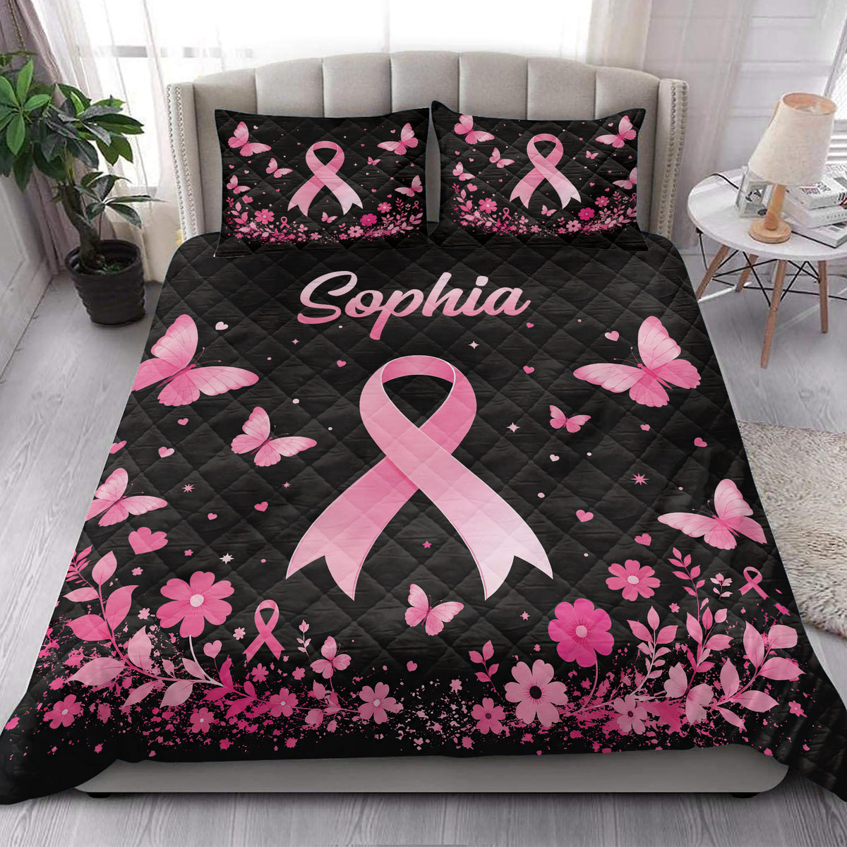 Breast cancer awareness quilt blanket styled on a bed with pink ribbons, butterflies, and floral borders
