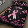 Close bedroom view of a black breast cancer quilt with large pink ribbon, butterflies, and flowers
