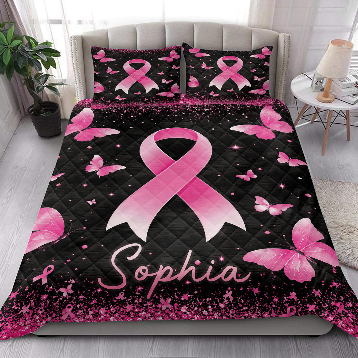 Breast cancer awareness quilt blanket styled on a bedroom bed with pink ribbons and butterflies