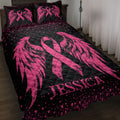 Black and pink breast cancer quilt blanket displayed on a bedroom bed with ribbon and wing artwork