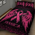 Close view of black and pink breast cancer quilt blanket with large ribbons, wings, hearts, and splatter details