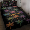 Black dragonfly quilt blanket spread across a bed with colorful dragonfly artwork and matching pillows