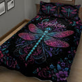 Close bedroom view of a black dragonfly quilt with jewel-toned wings and floral scrollwork