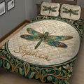 Close view of colorful dragonfly artwork and botanical border on a quilt blanket