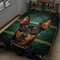 Close bedroom view of a Miniature Pinscher quilt blanket with green and gold ornamental design